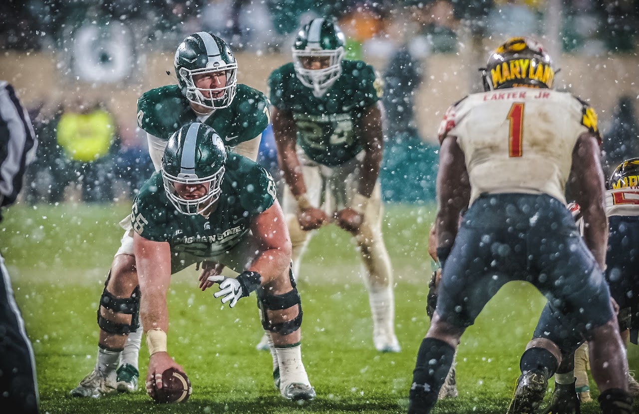 Athlete walking through rain under stadium lights